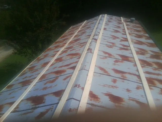 Rusted metal roof panels with new wood purlins before replacement — Storm Damage Roof Repair in March Air Reserve Base by Roofing Brothers
