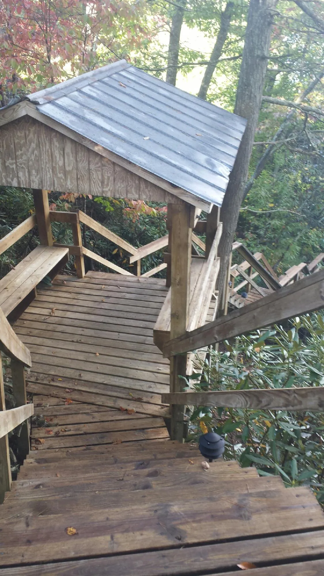 Metal roofed shelter over wooden steps on a wooded walkway — Skylight Repair & Installation work by our crew in March Air Reserve Base