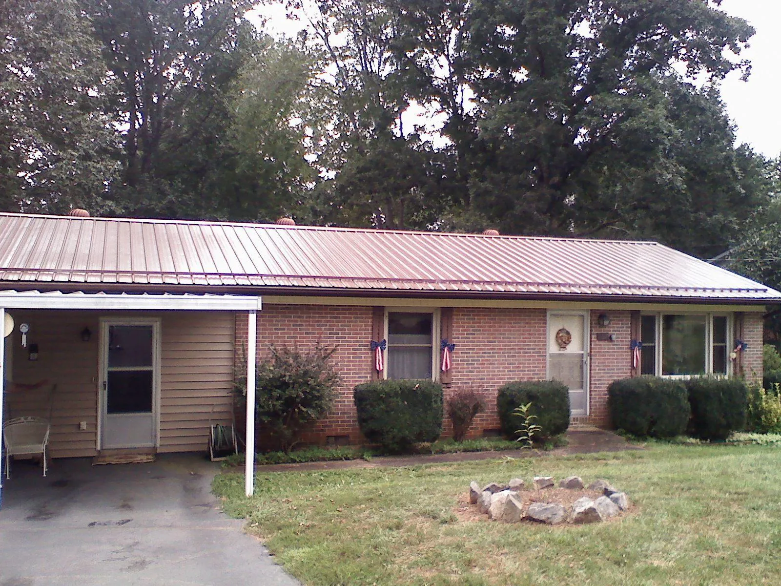 Bronze metal roof and carport on a brick ranch home — Roof Repair work by our crew in March Air Reserve Base