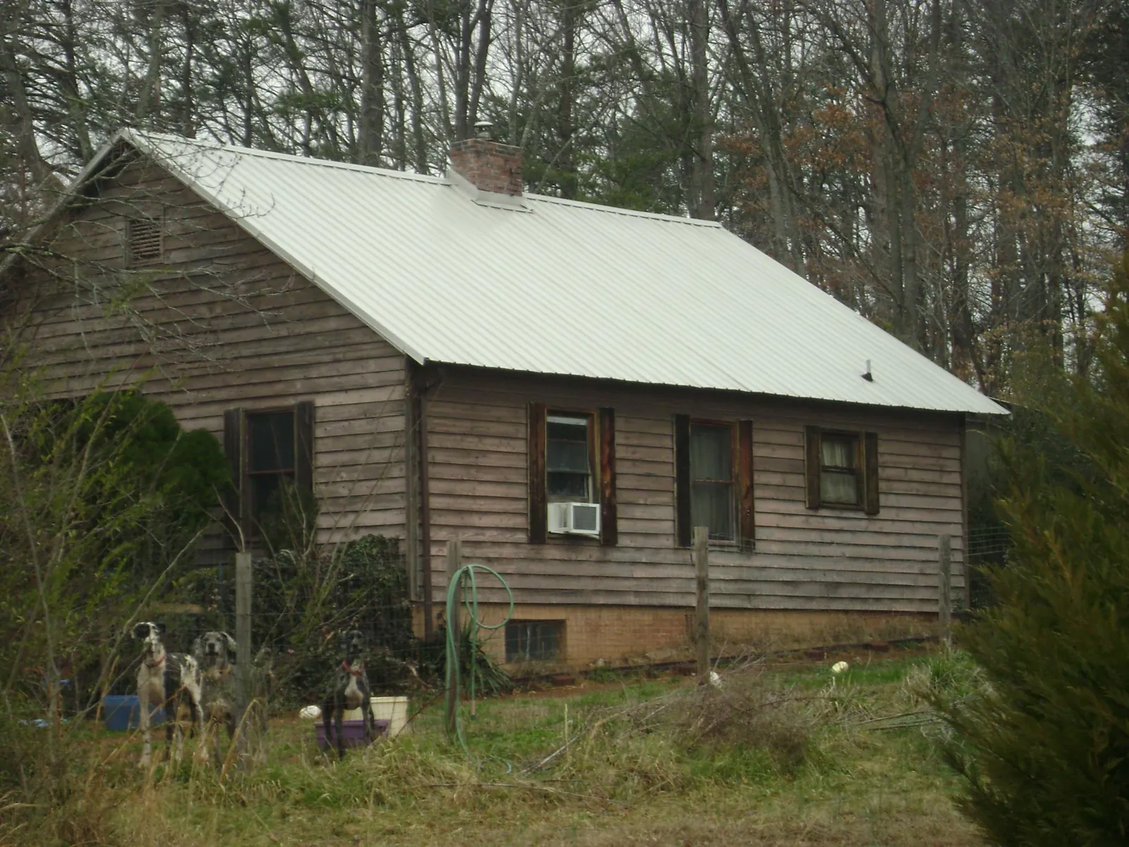 White metal roof on an old wood sided farmhouse, from a Metal Roof Installation job in March Air Reserve Base